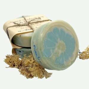 A bar of gentle Irish Sea Moss Soap for sensitive skin, resting on a bed of dried moss, showcasing its natural, creamy texture